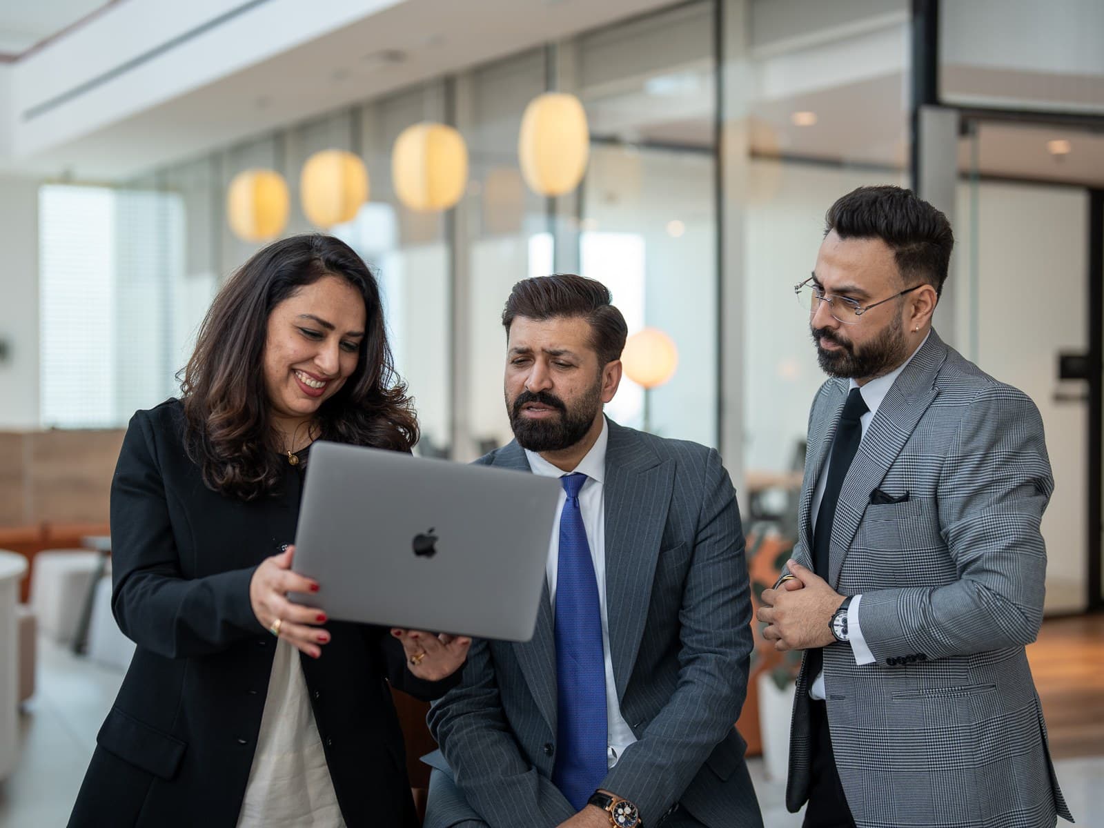 Three colleagues looking at a laptop together