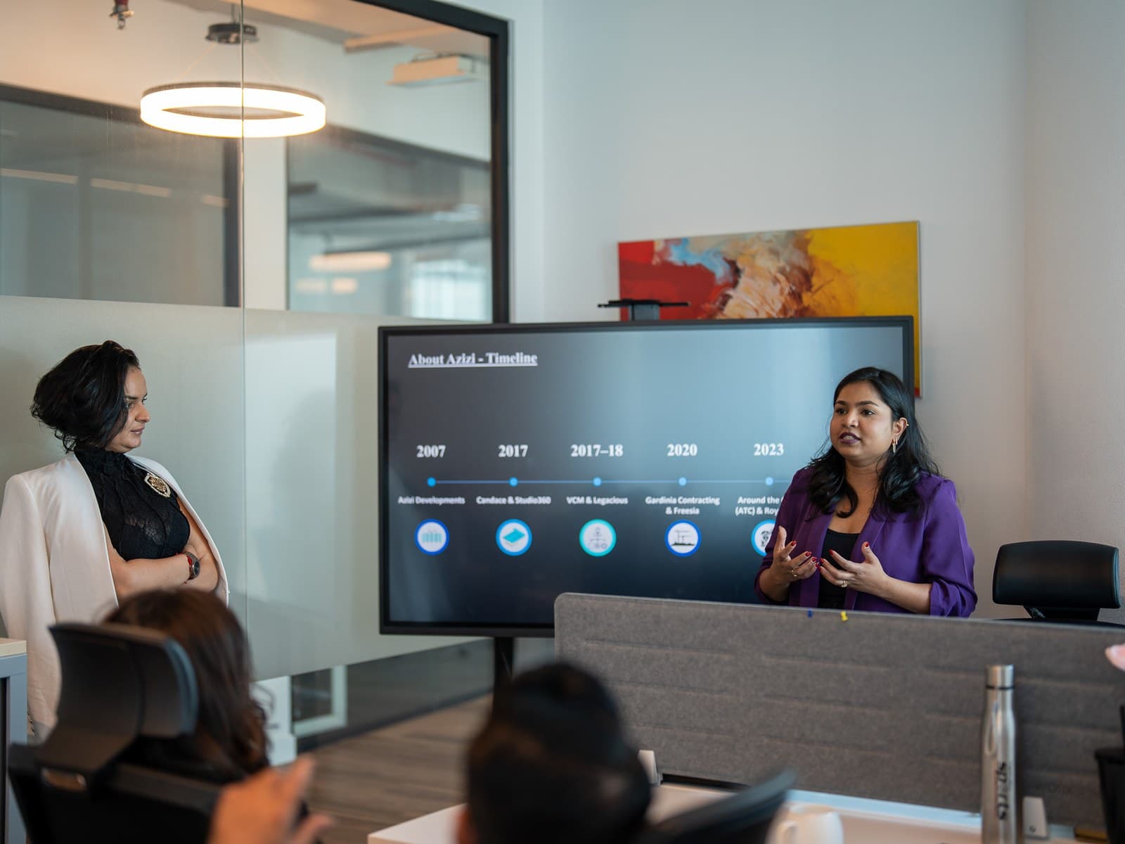 Colleagues watching a project timeline on screen during a meeting